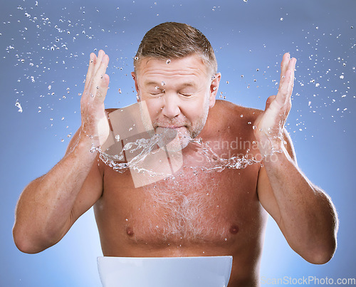 Image of Man cleaning face, skincare and water drops, hygiene and grooming with clean facial on blue background. Mature man washing skin, basin and hands with natural cosmetic care, wellness and dermatology