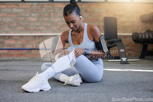 Image of Fitness, injury or sports woman with knee pain after exercising, body training accident in workout. Red glow, floor or injured Indian girl suffering from muscle tendon after legs exercise at gym club