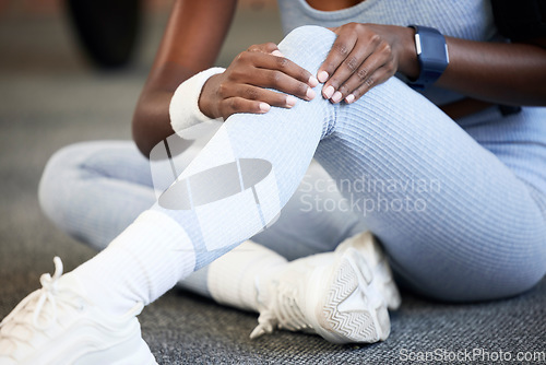 Image of Fitness, injury or hands on knee pain at gym after exercising, body training accident in workout on floor. Emergency or injured Indian girl suffering from muscle tendon after legs exercise in a club