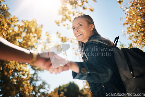 Image of Woman, smile and holding hands in nature with backpack for travel, trip or couple adventure. Happy female touching hand smiling in park with bag for summer bonding, traveling or outdoor holiday break