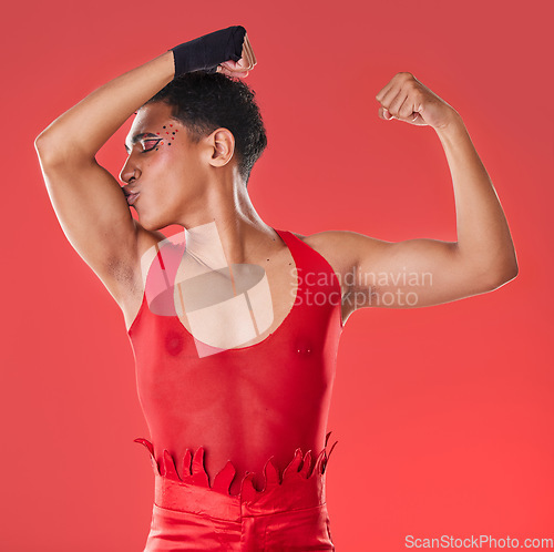 Image of Man, studio and arm muscle kiss with wrestling, punk costume and makeup for lgbt aesthetic by red background. Young bodybuilder, gen z gay and fitness with strong body, self care and pride for health