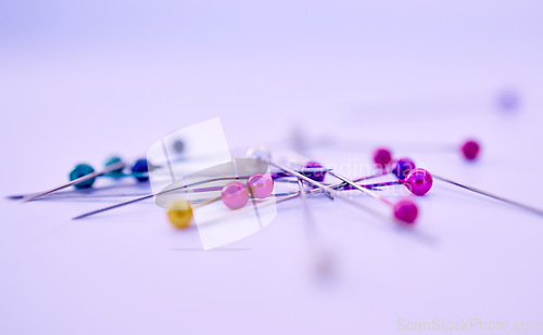 Image of Closeup, sewing pin and design in studio by purple background for clothing manufacturing in factory. Macro, metal needles or table for fashion, clothes or workshop for tailor, designer or seamstress