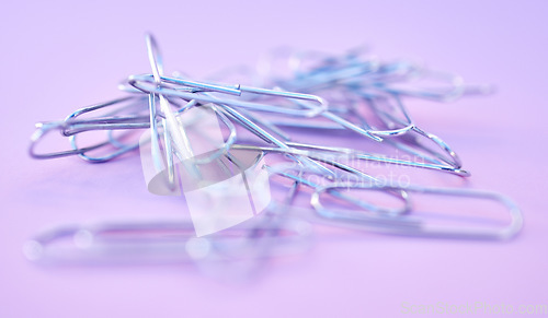 Image of Paper clips together in pile, connected and a chain on purple background. Office supplies, organization and project management with paperclip for business strategy and planning to organize paperwork.