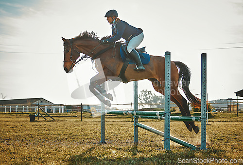 Image of Training, jump and woman on a horse for sports, an event or show on a field in Norway. Equestrian, action and girl doing a horseback riding course during a jockey race, hobby or sport in nature