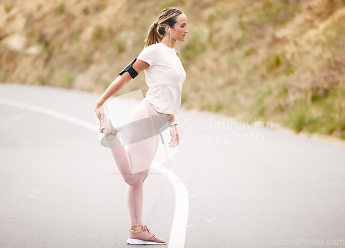 Image of Runner, leg stretch and woman in a road with music for fitness, cardio and mindset preparation. Girk, stretching and nrunning in nature with podcast, radio or wellness motivation track for workout