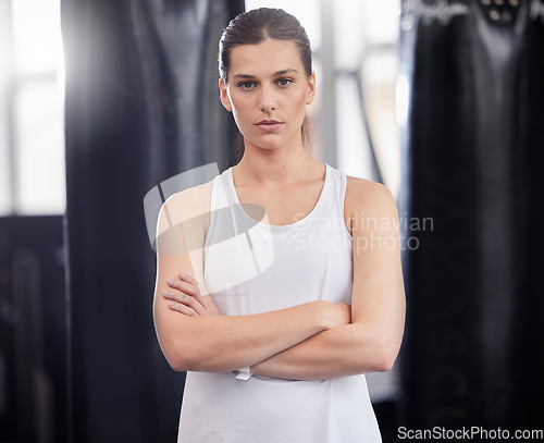 Image of Portrait, fitness and boxing with a sports woman in a gym, standing arms crossed feeling serious or confident. Exercise, training and focus with a female boxer or athlete standing in a health studio