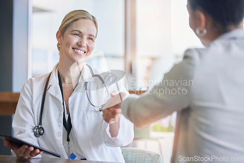 Image of Handshake, healthcare or trust with a doctor woman and patient in a hospital for a checkup or diagnosis. Medical, wellness and insurance with a medicine professional shaking hands to say thank you