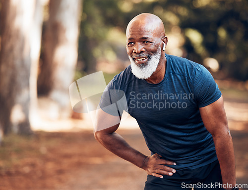 Image of Black man, break from running and relax with fitness, vitality and cardio, senior runner in the park. Exercise, earpods and listen to music for motivation, tired with endurance and health outdoor