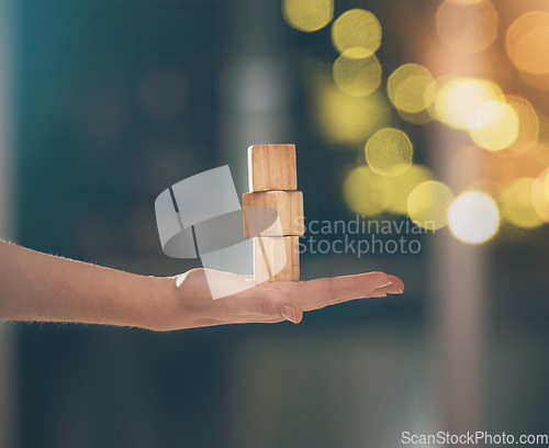 Image of Hand, building blocks and balance with a business woman holding wood for growth on a blurred background. Investment, portfolio and stack with the foundation of a company built on financial stability