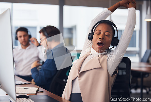 Image of Tired black woman, yawning and stretching in call center for break in customer services or desktop support at office. African American female exhausted consultant in arm stretch from telemarketing