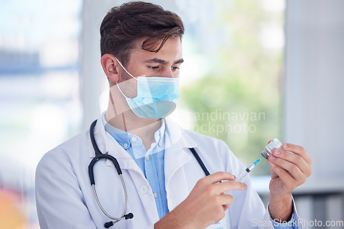 Image of Man, doctor and hands with face mask, vaccine or syringe for cure, illness or medication at the hospital. Male medical professional extracting medicine from vial for covid immunization or disease