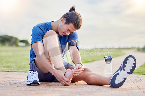 Image of Fitness, sports injury and foot pain with man in park for muscle spasm, inflammation and joint problem. Running, workout and exercise with athlete and emergency for health, suffering and broken ankle