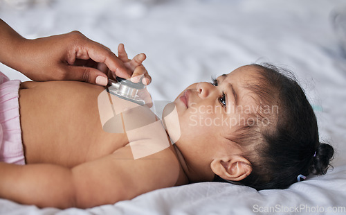 Image of Healthcare, stethoscope and sick baby on a bed for a consultation in a children medical clinic. Infant girl kid with a cold, flu or illness getting a wellness examination or checkup at the hospital.