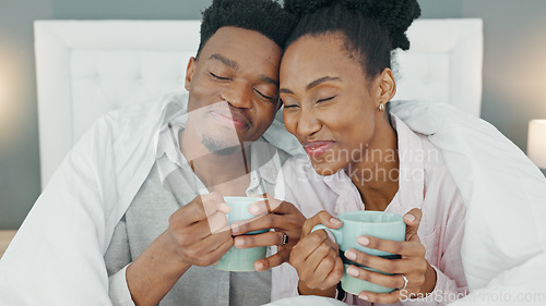 Image of Coffee, bed and couple with a man and woman in the bedroom to relax in their home together. Drink, tea and romance with a young male and female sitting in their house in the morning over a weekend