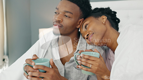 Image of Love, couple and coffee in bed with a black woman and man in the bedroom to relax in their home. Young african american male and female drinking tea and relaxing in their house on the weekend