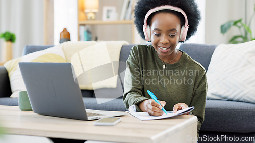 Image of Woman talking on videocall using laptop and headphones while waving hello to friends online. Student making notes while communicating and learning new language during online course or private lesson
