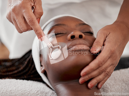 Image of Facial roller, spa and black woman relax for massage, wellness and skincare cosmetics at salon. Beauty, face and beautician with rose tool for healthy dermatology, crystal stone and aesthetic glow