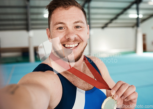 Image of Gymnastics, fitness and male athlete taking a selfie after winning a medal in competition. Sports, smile and portrait of happy male gymnast winner taking a picture after training or practice in arena
