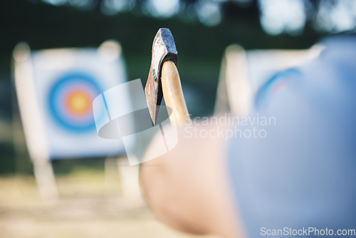 Image of Man throwing axe at sports range, archery training or practice with board circle for goal, game and exercise. Strong person closeup with weapon for tomahawk competition, gaming park and eye target