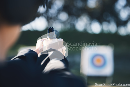 Image of Firearm, target and person training outdoor at shooting range for game exercise or sports challenge closeup. Man hands with gun, circle and aim for practice, police academy or field practice mission