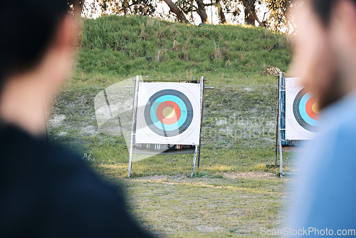 Image of Target, archery coach or bow and arrow learning for archer competition, athlete challenge or girl training practice. Sports teacher, teaching talk or man coaching woman on precision, aim and shooting