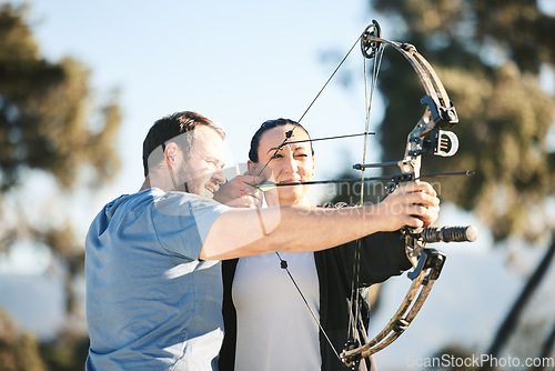 Image of Archery, shooting range and sports training to aim with a woman and man outdoor for target practice. Archer and athlete person with focus on field for competition or game to shoot arrow for action