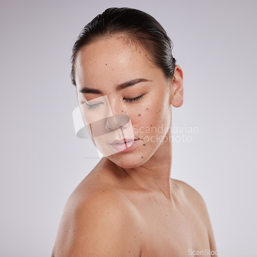 Image of Skincare, beauty and woman in studio for cosmetics, dermatology and skin glow. Aesthetic asian model person with makeup, mole and luxury facial self care for health and wellness on grey background