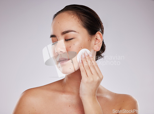 Image of Face, skincare cotton and woman with eyes closed in studio isolated on a gray background. Makeup hygiene, beauty aesthetics and young female model with facial pad or product for cleaning cosmetics.