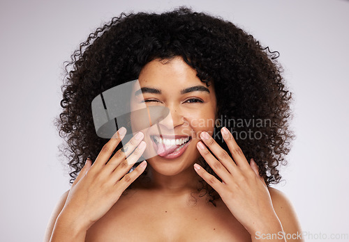 Image of Black woman, tongue and afro in studio portrait with beauty, wellness and cosmetic skincare glow by background. Young gen z model, african and cosmetics with funny face, natural and healthy aesthetic