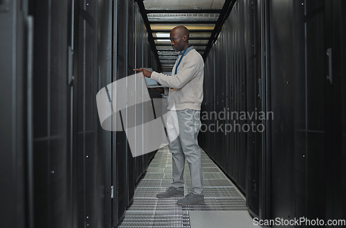 Image of Laptop, maintenance and server room with IT black man for research, engineer working in dark data center. Computer, cybersecurity and analytics with male programmer problem solving or troubleshooting