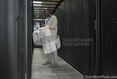 Image of Server room, data center or IT black man with laptop for research, engineer working in dark server room. Computer, cybersecurity and analytics with male programmer problem solving or troubleshooting