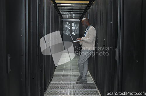 Image of Laptop, network and data center with IT black man for research, engineer working in dark server room. Computer, cybersecurity and analytics with male programmer problem solving or troubleshooting