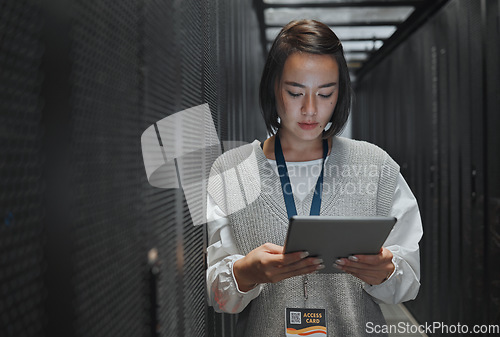 Image of Tablet, server room and cloud computing with a programmer asian woman at work on a mainframe. Software, database and information technology with a female coder working alone on a cyber network