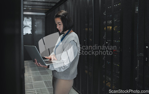 Image of Server room, laptop and technician woman for data center management, system update and cyber security. Focus, serious and inspection of asian electrician, engineering or programmer person typing code