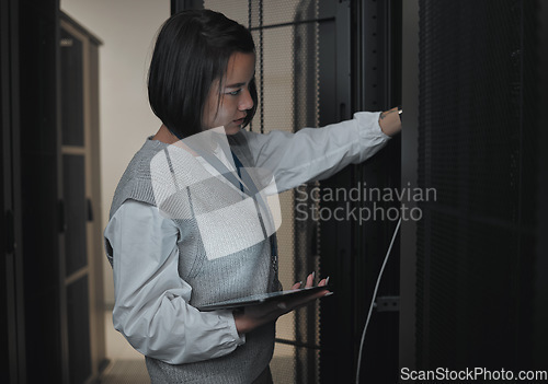 Image of Tablet, server room and engineering with a programmer asian woman at work on a computer mainframe. Software, database and information technology with a female coder working alone on a cyber network