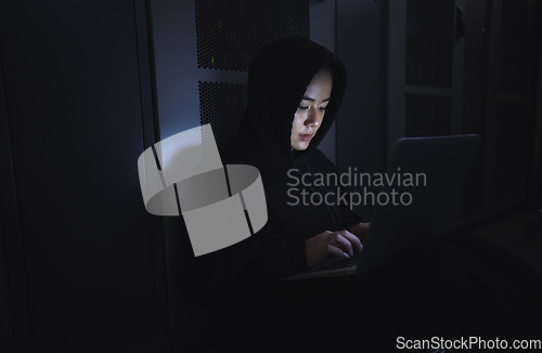 Image of Hacker, server room and person on laptop for coding software, data center crime and cyberpunk in dark. Network hacking, woman or user in cybersecurity, information technology or programmer ransomware