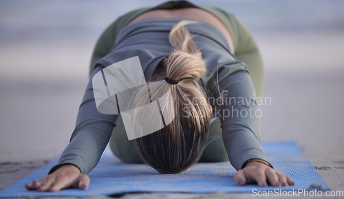 Image of Woman, yoga and stretching on beach for spiritual wellness, zen or workout in nature. Female yogi in warm up stretch, shishosana pose or pilates for healthy exercise or fitness by the ocean coast