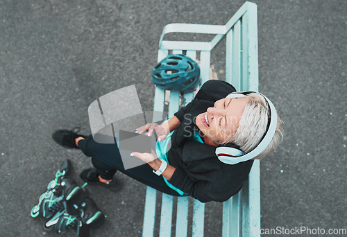 Image of Phone, happy and woman roller skating with music for training, exercise and fun on a city bench. Laughing, mobile and above of a mature lady listening to a podcast while ready to start a skate