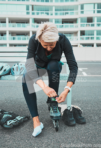 Image of Roller skate, tie and senior woman in city ready for sports, adventure and fitness hobby outdoors. Exercise, holiday and elderly female tying shoelace from skating, travel and journey in road