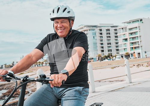 Image of Mature man, helmet or electrical bike by beach for future fitness, clean energy transport or sustainability travel. Happy person, technology or electric bicycle, head safety or eco friendly cycling