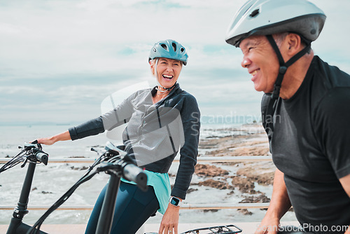 Image of Laughing couple, helmet or electrical bike by sea in transportation, clean energy or sustainability travel bonding. Technology, electric or eco friendly bicycle for funny woman or mature cycling man