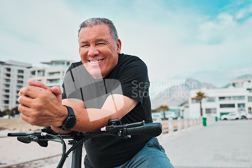 Image of Portrait, bike and cycling with a senior man on the promenade, riding eco friendly transport for travel. Face, smile and health with a happy mature male cyclist sitting on his bicycle outdoor