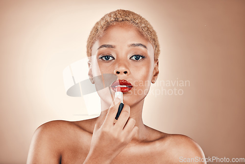 Image of Black woman, makeup and portrait with red lipstick on a brown background for beauty cosmetics. Aesthetic model or focus person in studio for skincare, self care and facial glow on skin and bold lips