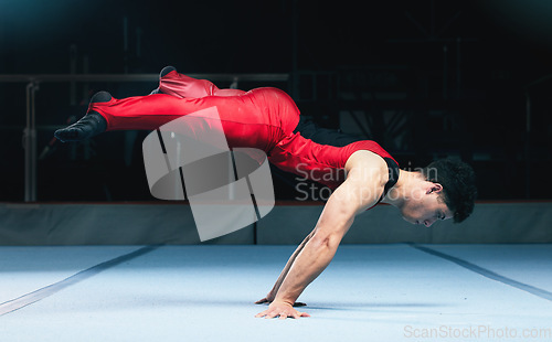 Image of Gymnast, handstand and man on gym floor for training, balance and wellness with muscle, strong body and night. Gymnastics, athlete and exercise in studio for competition, goals and fitness for sport