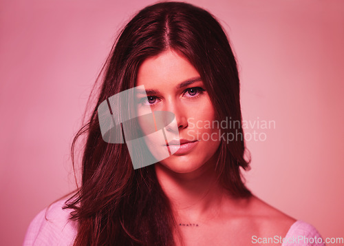 Image of Portrait, neon and gen z with a model woman in studio on a pink background for beauty or skincare. Face, art and fantasy with an attractive young female posing on a color wall for a retro aesthetic