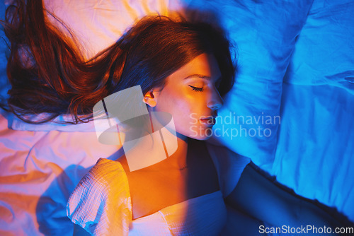 Image of Sleeping beauty, lights and woman with sleep and creative neon lighting. Resting, face and model glow and feeling relax and calm on a bed pillow with aesthetic profile in a bedroom bed at home