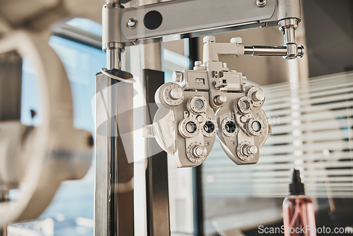 Image of Vision, optometry and healthcare in an optician office with an ophthalmic phoropter machine for testing. Hospital, medical and eye health with test equipment in an empty room at the optometrist