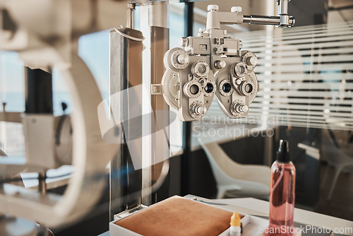 Image of Vision, optometry and eye health in an optician office with an ophthalmic phoropter machine for testing. Hospital, medical and healthcare with test equipment in an empty room at the optometrist