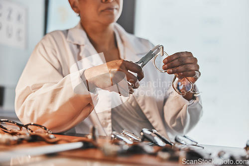 Image of Senior optometrist, hands and tools with glasses, maintenance and frame design planning at desk. Elderly optician, spectacles designer and eye product in workplace for health, small business and goal