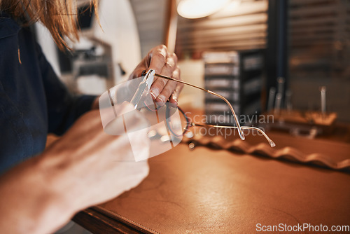 Image of Hands, glasses and optometry with an optician working in an office, cleaning eyewear for vision. Healthcare, eyeglasses and insurance with an optometrist at work in a clinic for prescription lenses